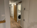 Paxto-II-Pantry-Cabinet-in-Hall-and-Barn-Door-in-Laundry-Room-Matching-Beams